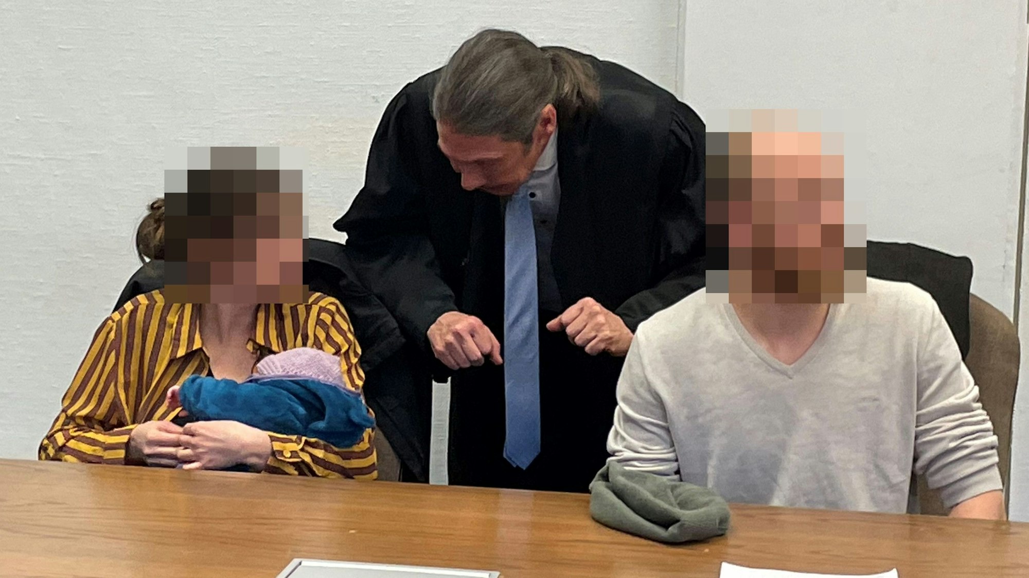 Die Angeklagten mit Baby und Verteidiger Ingo Lindemann beim Prozess vor dem Kölner Amtsgericht.