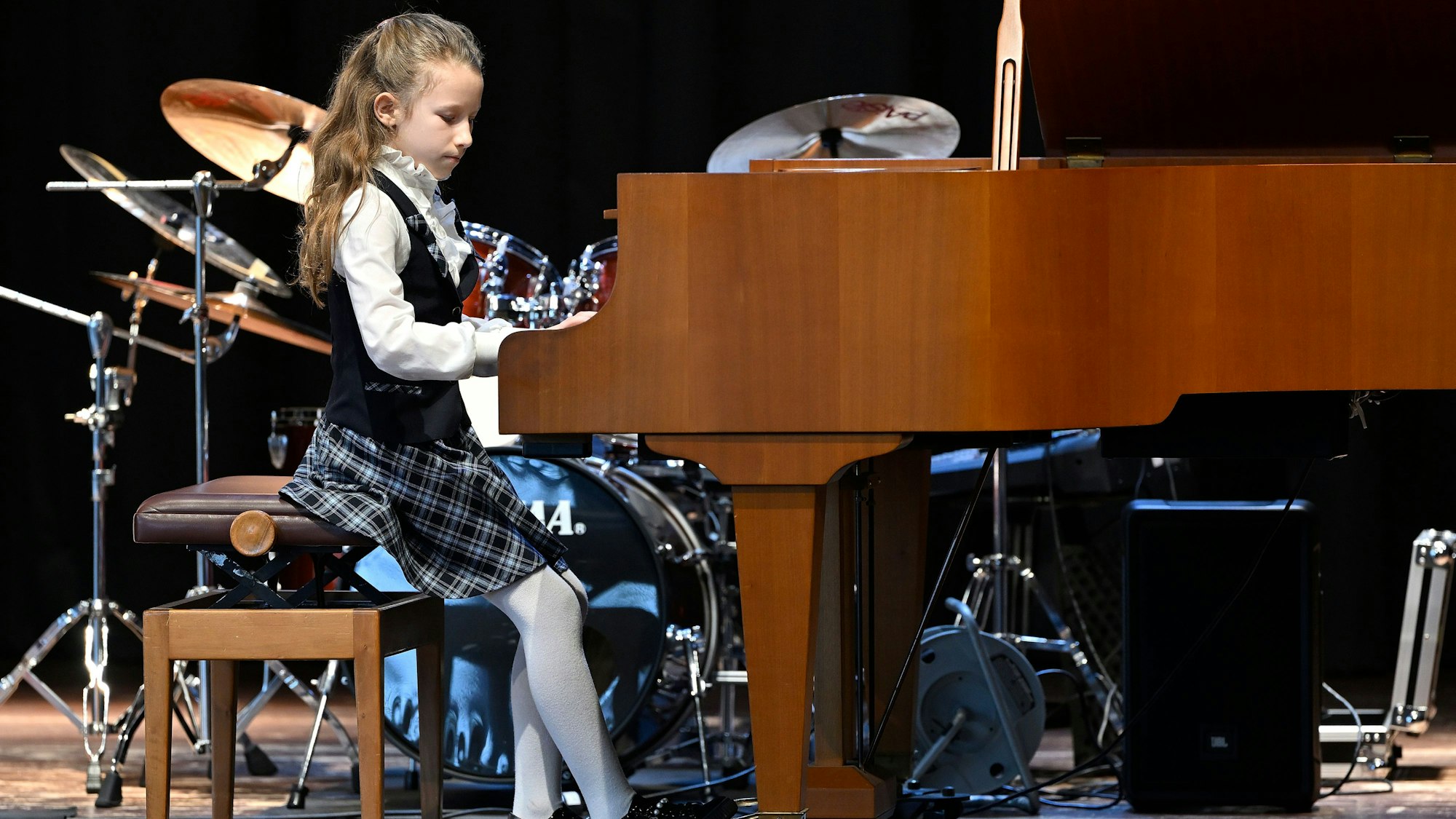 Ein Mädchen sitzt an einem Flügel und spielt.