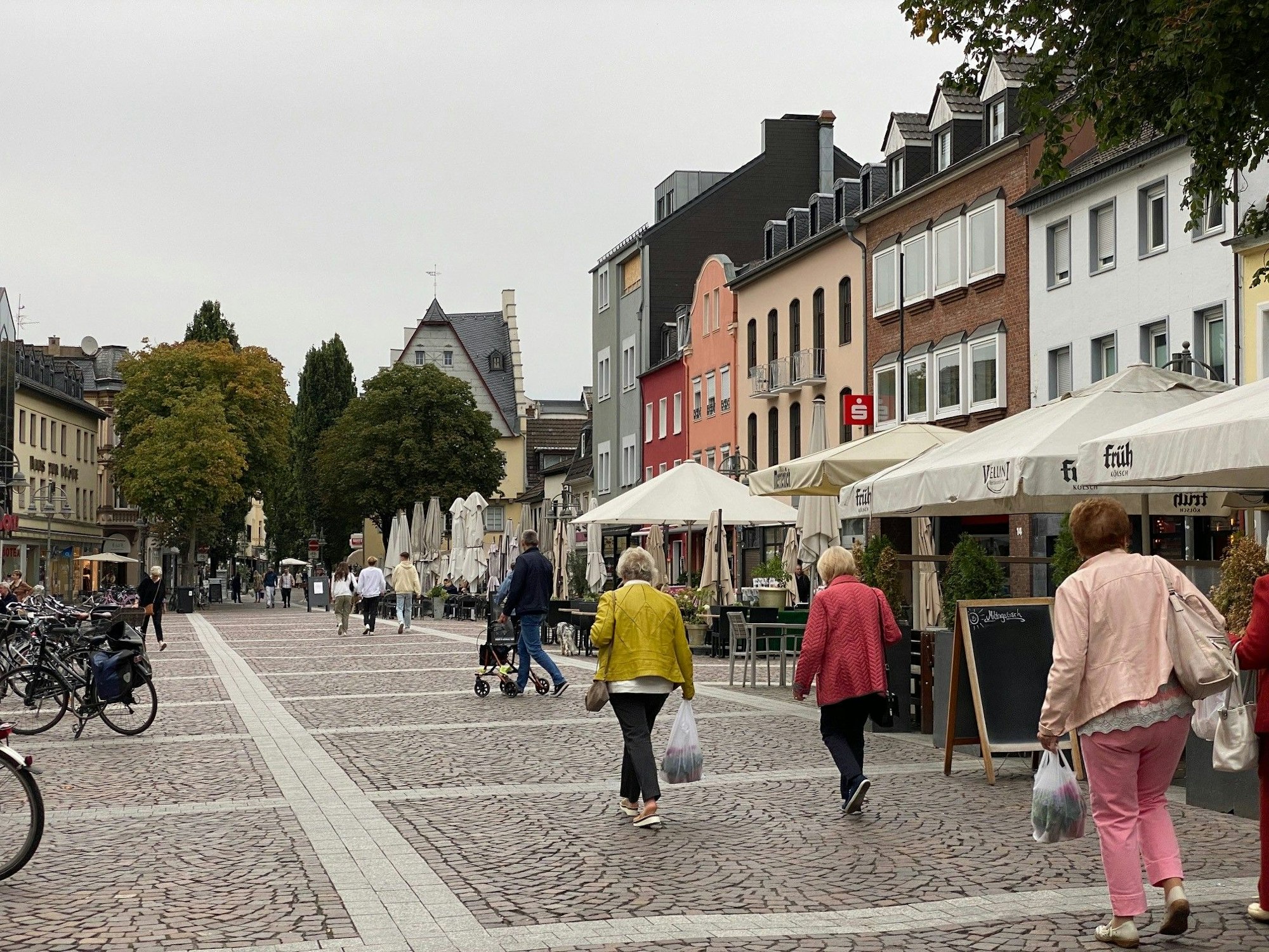 Fußgängerinnen laufen über den Brühler Marktplatz.
