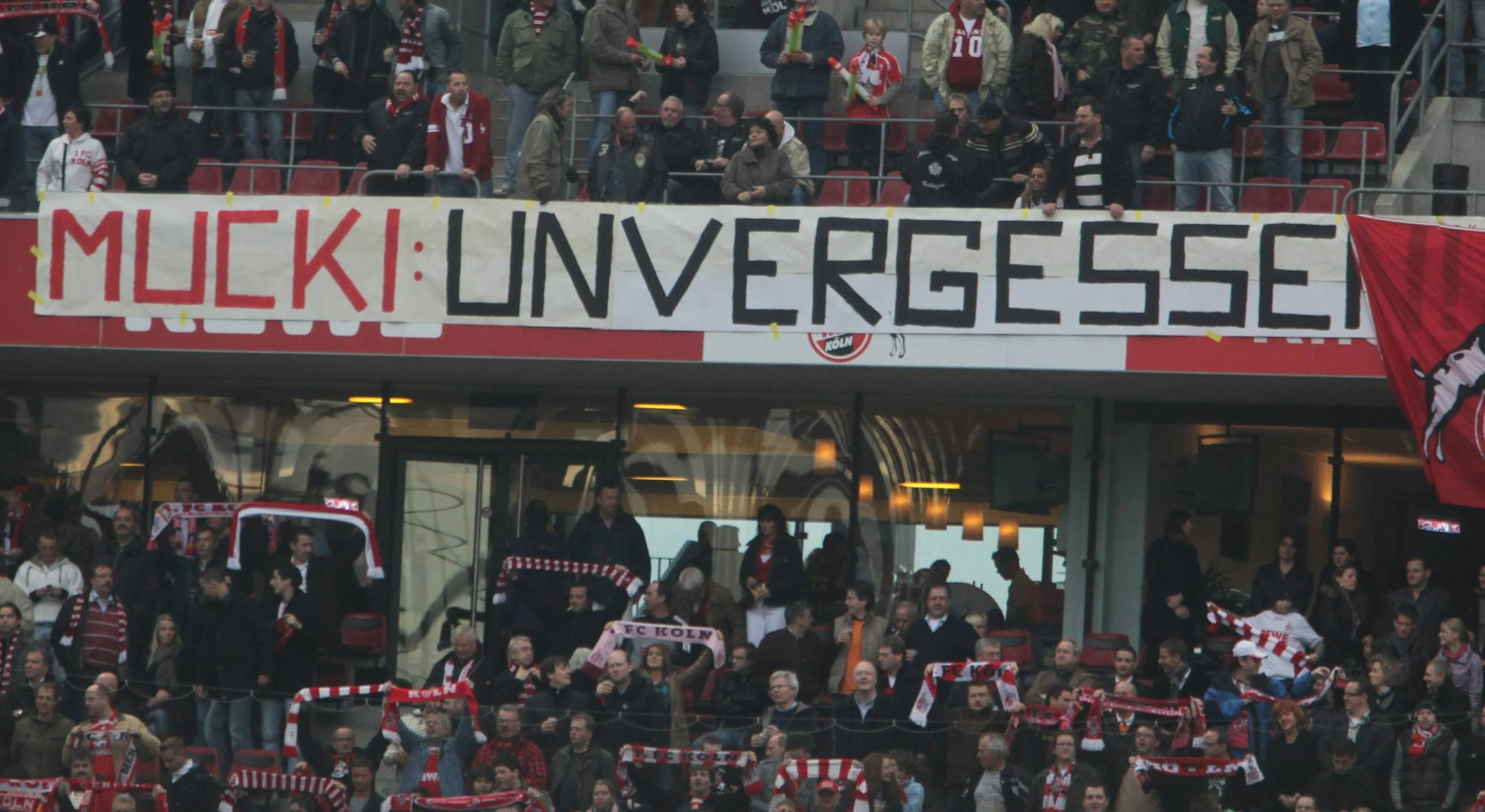 Über die Bandenwerbung des Oberrangs in einem Fußball-Stadion hängt ein Banner mit den Worten: „Mucki: unvergessen.