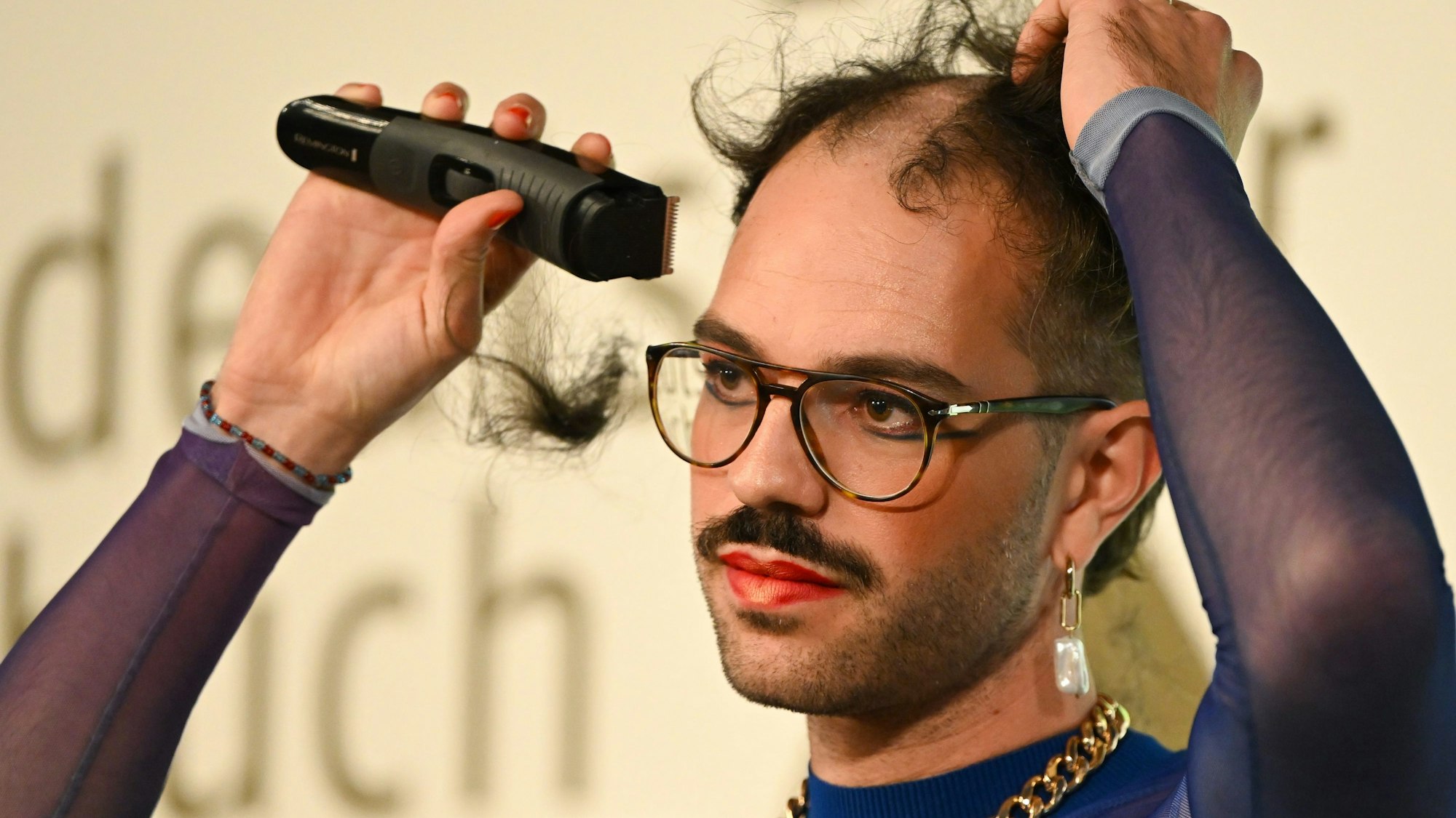 17.Oktober 2022: Kim de l'Horizon rasiert sich nach Gewinn des Deutschen Buchpreises 2022 im Frankfurter Römer die Haare ab.