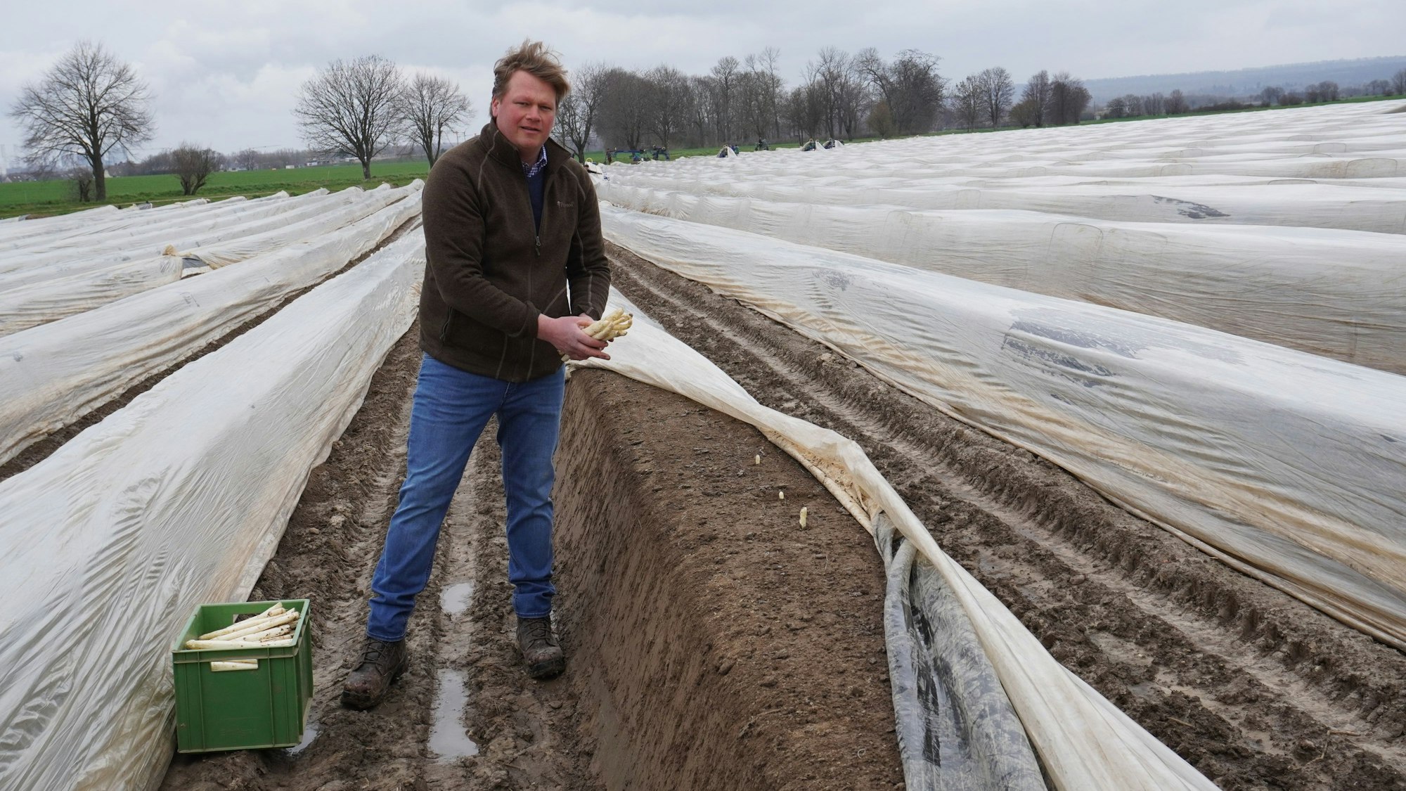 Auf dem Foto ist Johannes Nagelschmitz zu sehen. Die ersten Spargelstangen recken ihre Köpfe aus der Erde.