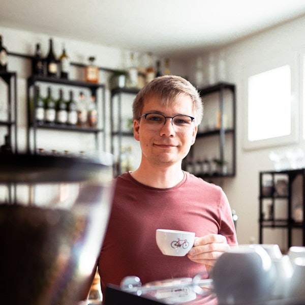 Ein Barista hat eine Kaffeetasse in der Hand.