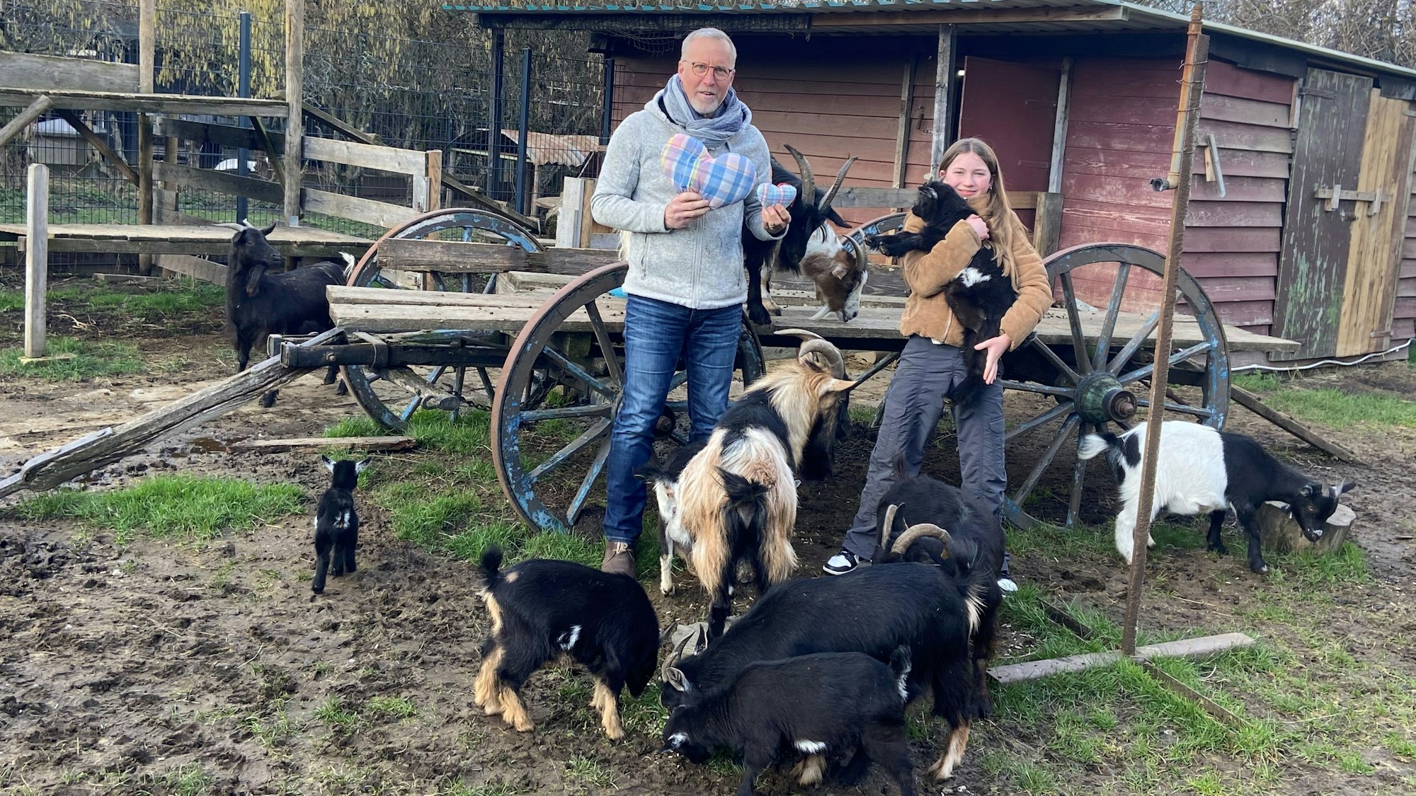 Ein Mann und ein Mädchen stehen im Streichelzoo.