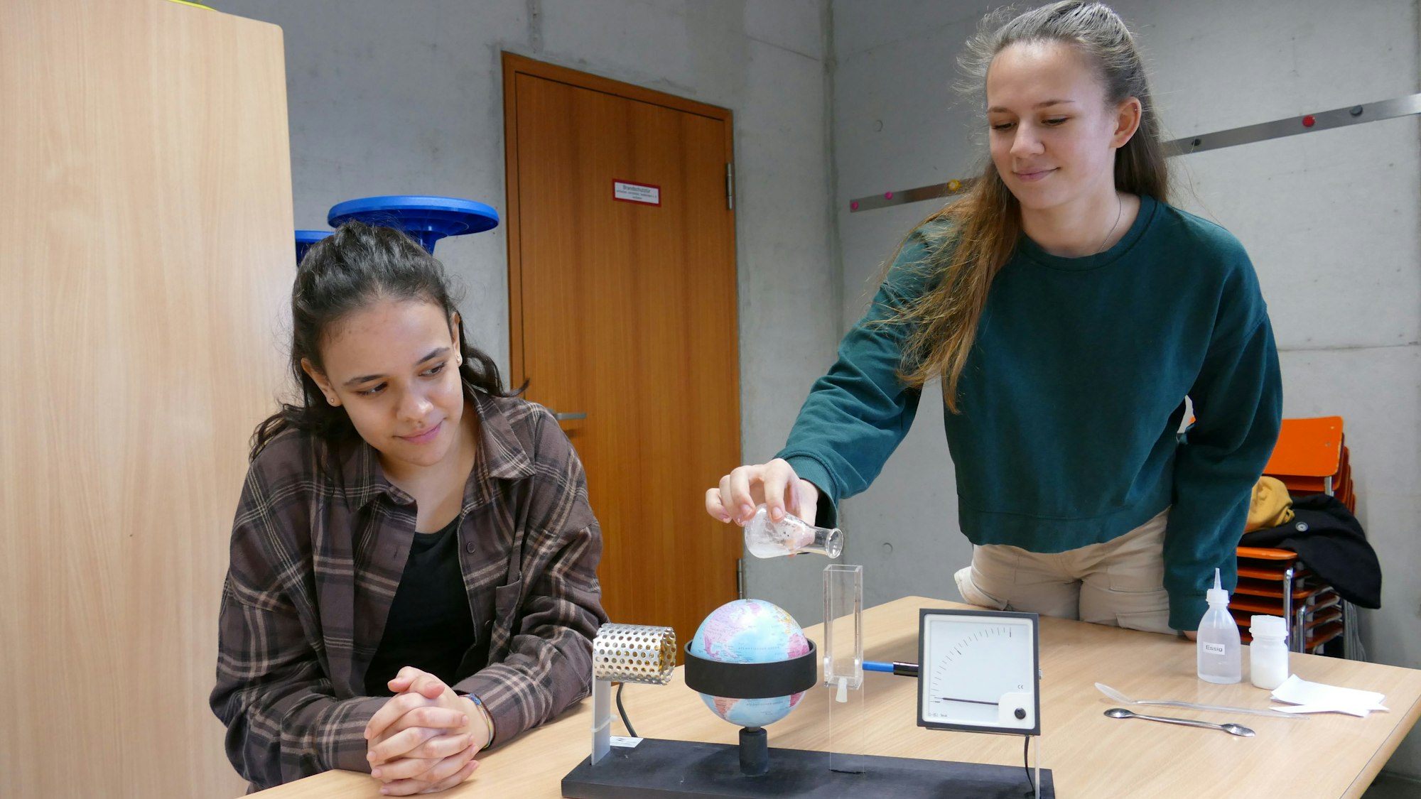 Zwei Schülerinnen an einem Klimatestgerät.
