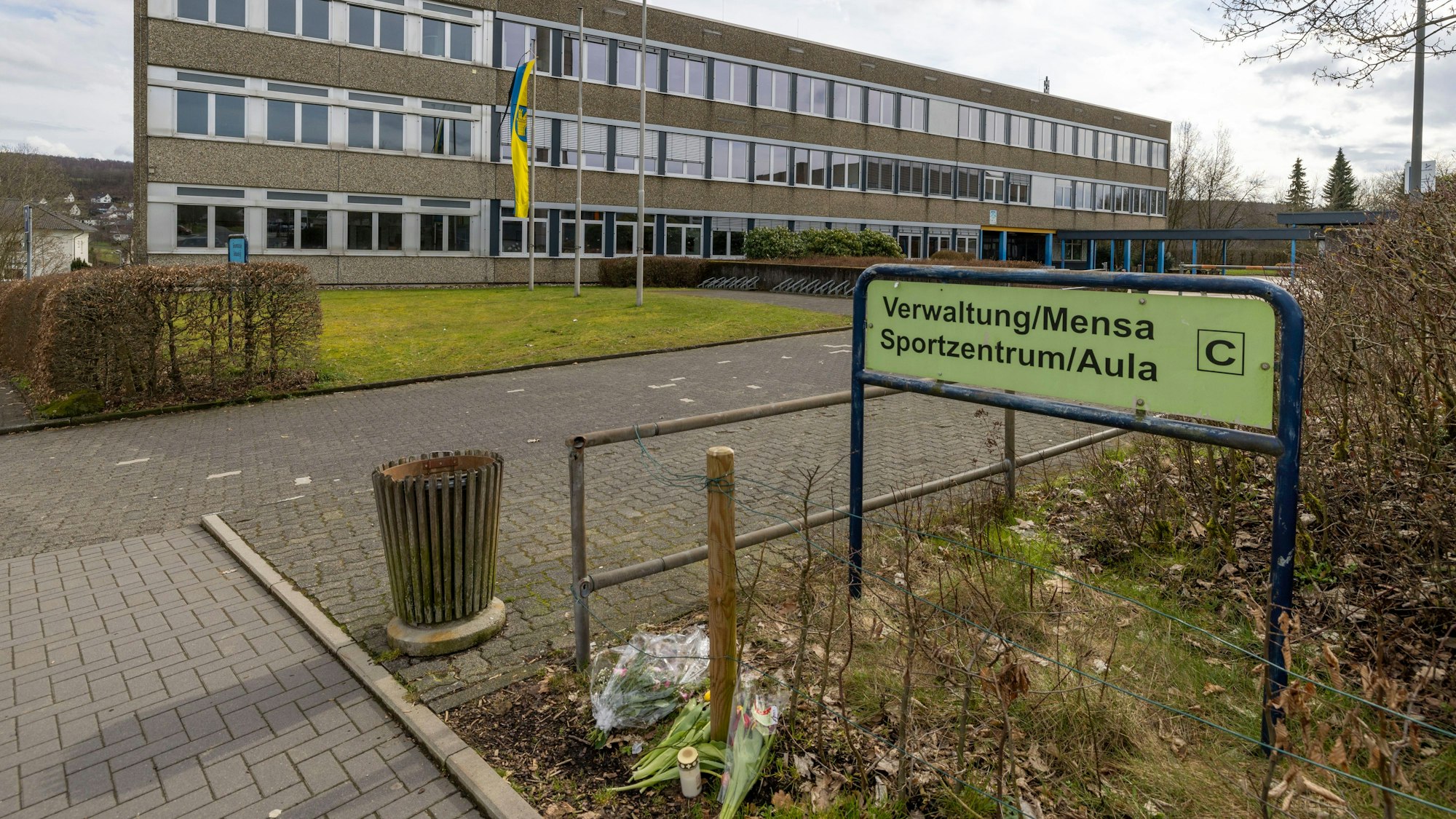 Luises Schule in Freudenberg: Vor dem Gebäude liegen Kerzen und Blumen in Gedenken an die getötete Zwölfjährige.