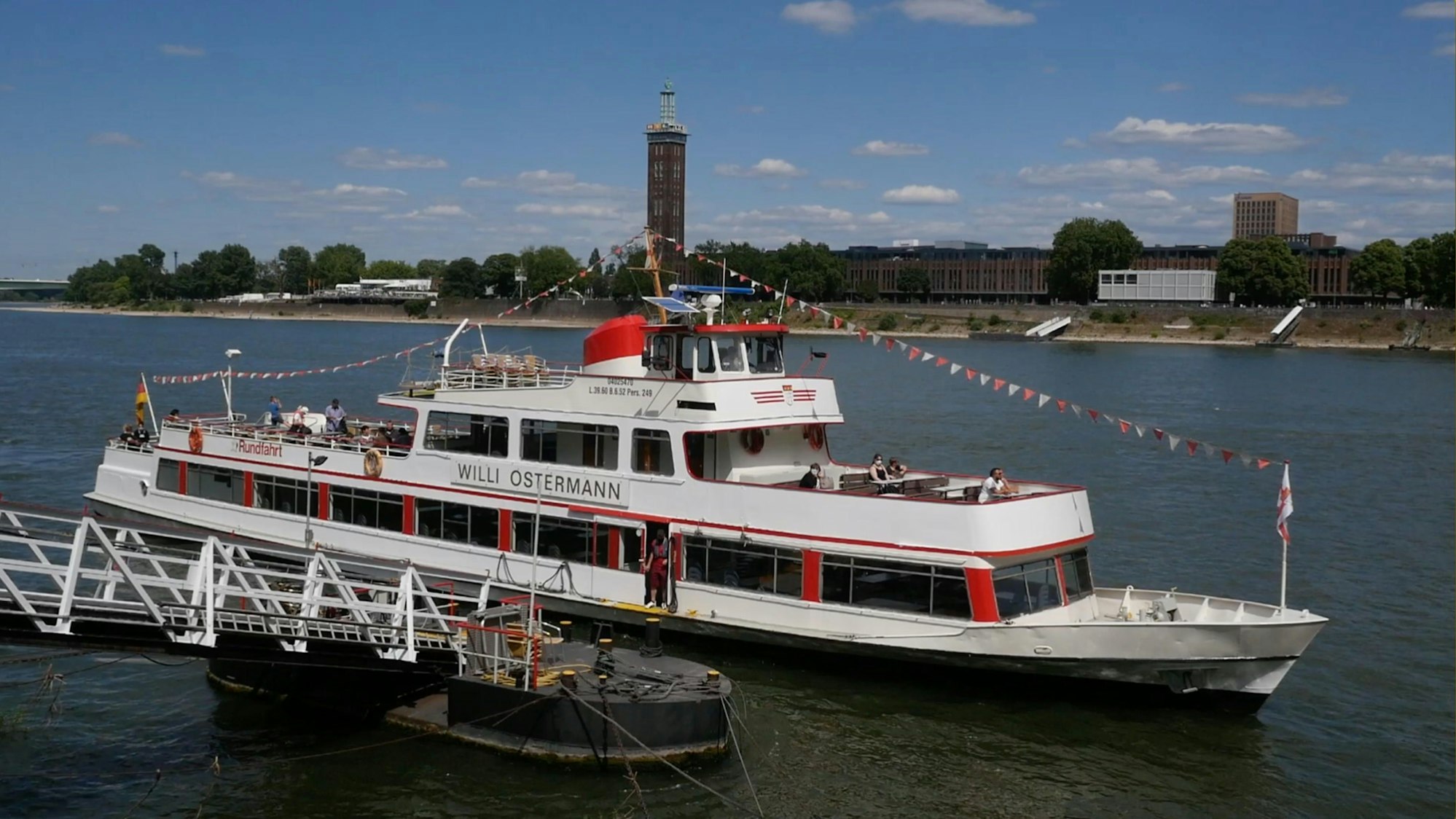 Die „Willi Ostermann“, das letzte Müllemer Böötchen, am Anleger, im Hintergrund das Messegelände