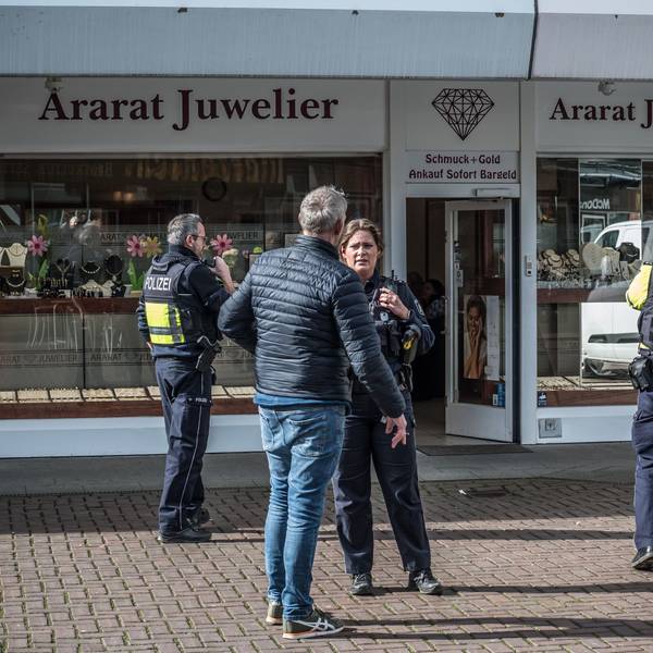 Polizisten und Zivilisten stehen vor dem Juwelier Ararat in Wiesdorfs City B.