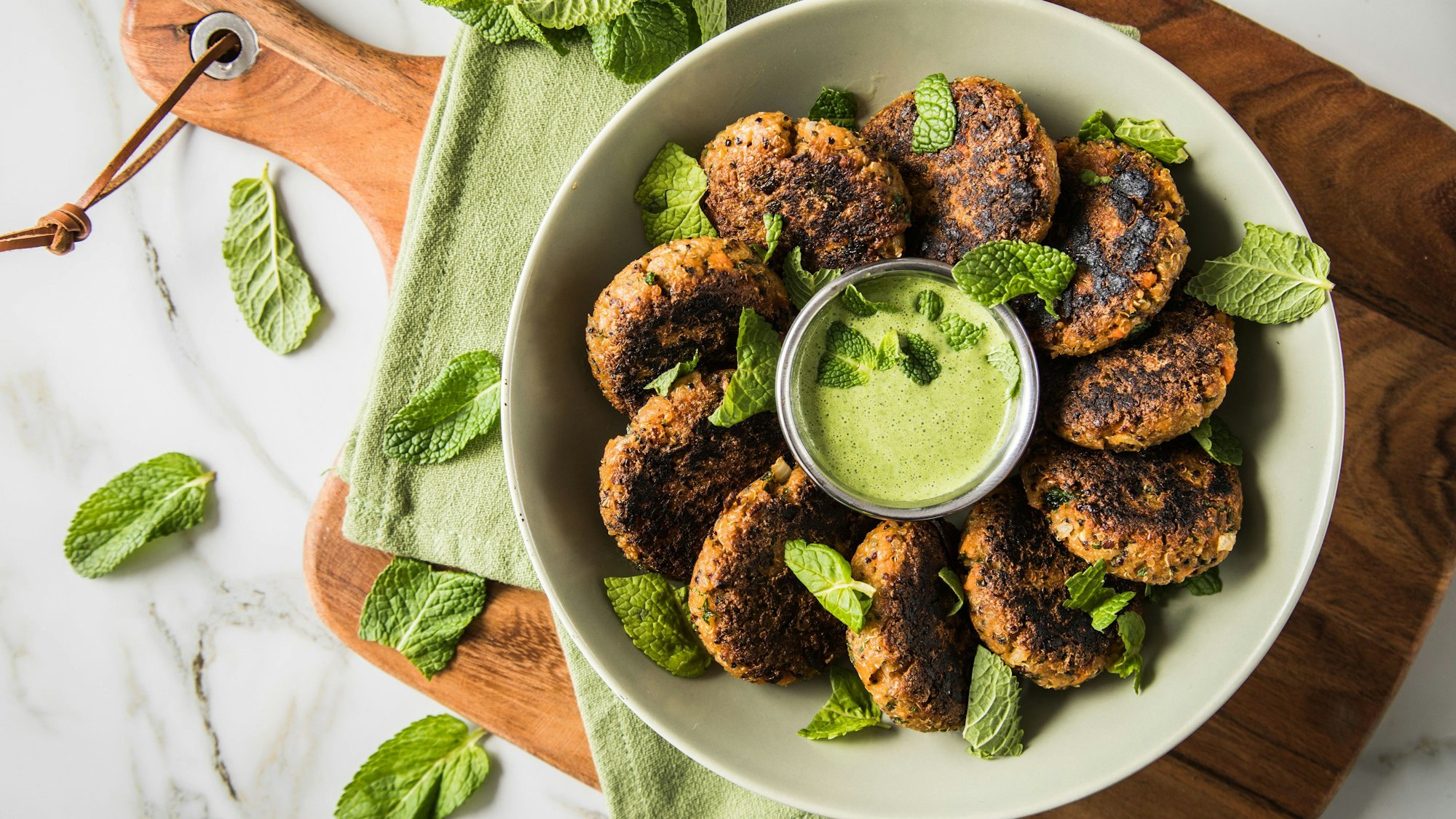 vegetarische Bratlinge mit grünem Dip angerichtet auf einem Teller