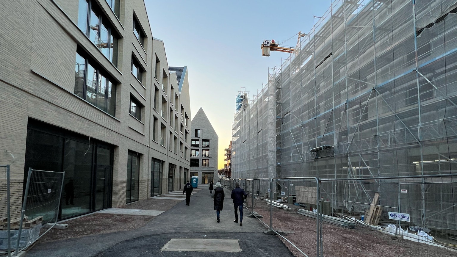Menschen spazieren durch eine Baustelle.