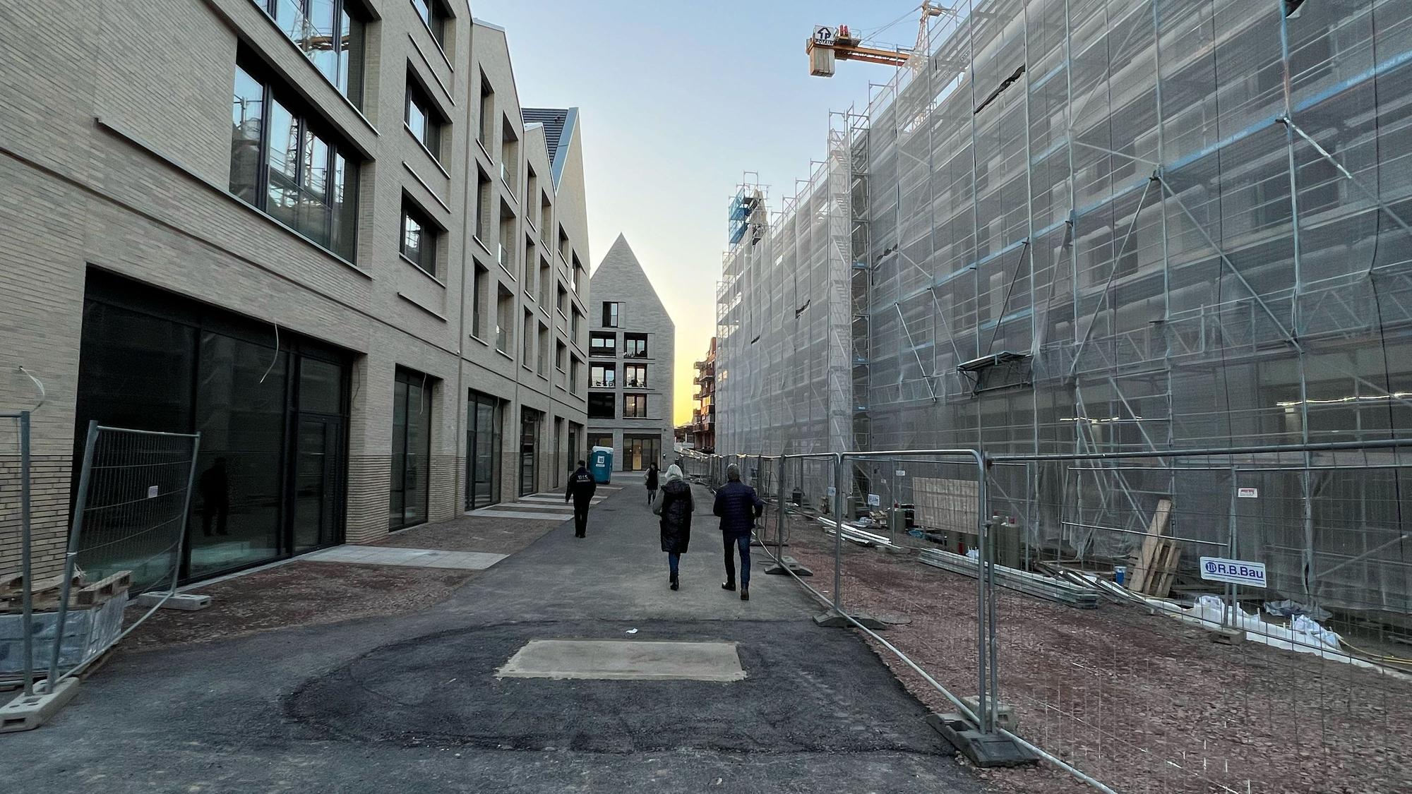 Menschen spazieren durch eine Baustelle.