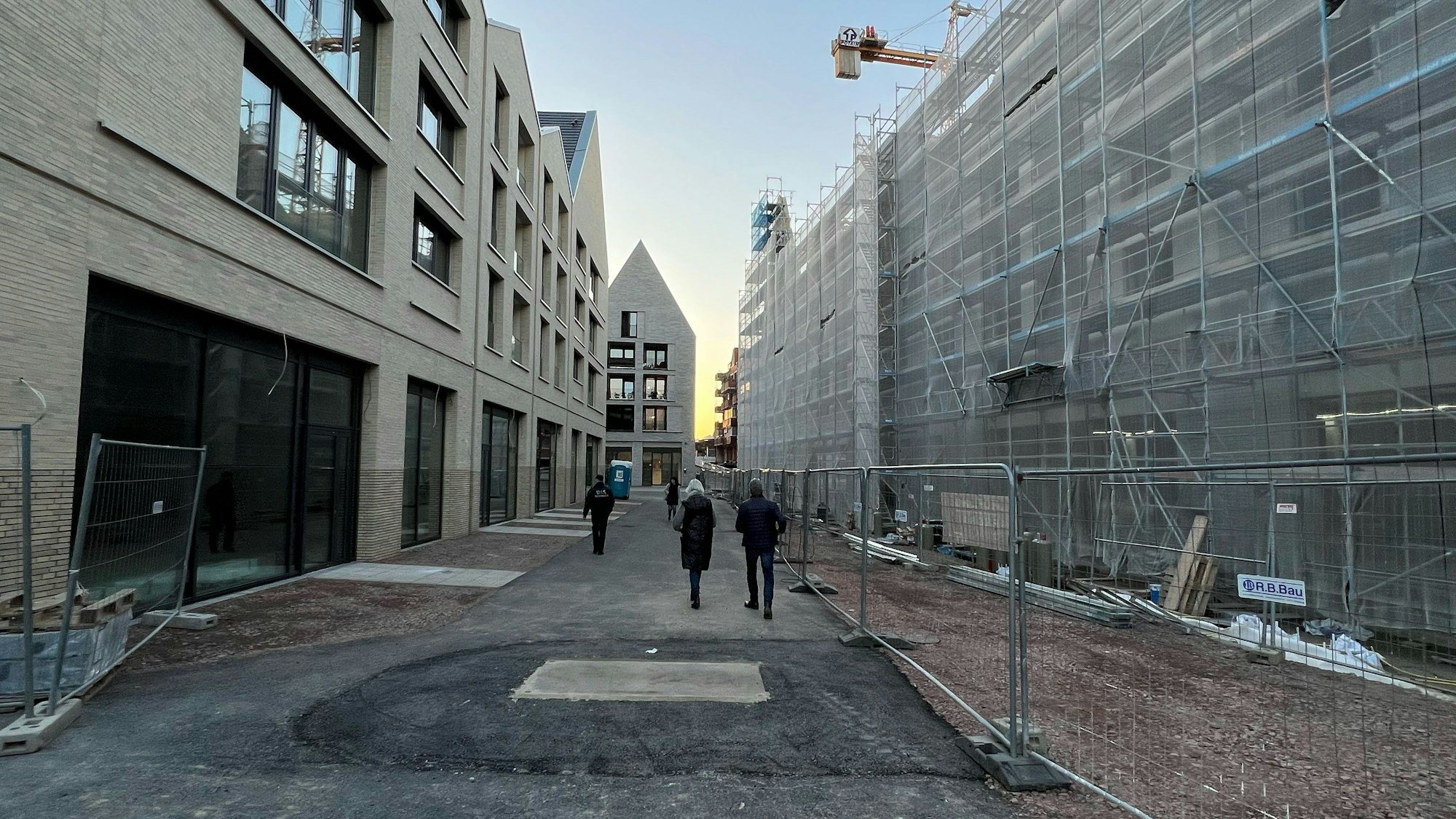 Menschen spazieren durch eine Baustelle.