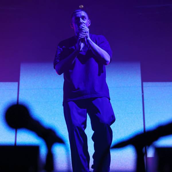 Sänger Dermot Kennedy steht auf der Bühne im Palladium. Er hält ein Mikrofon in der Hand. Zwei Mikrofone sind verschwommen im Vordergrund.