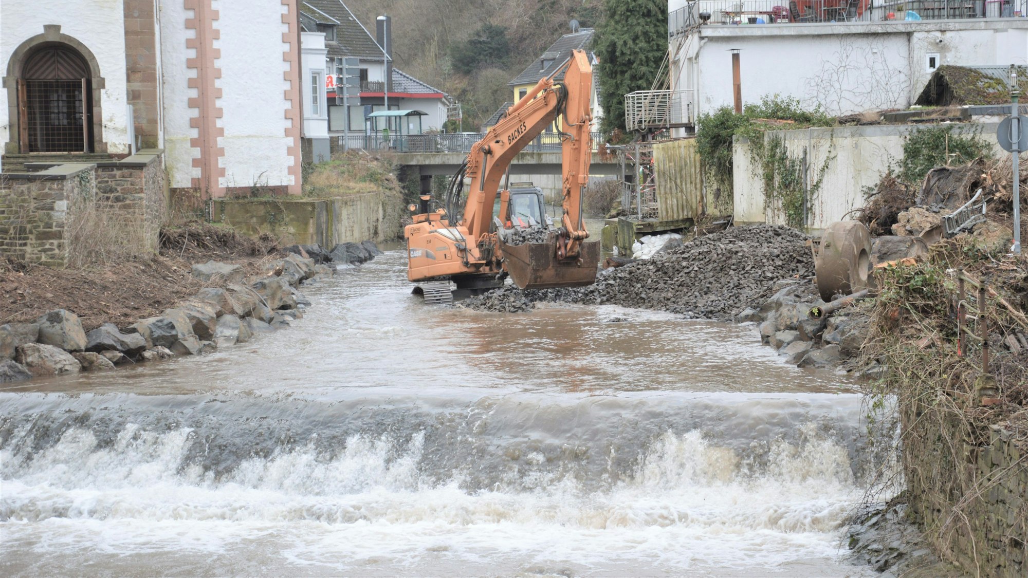 Das Bild zeigt einen Bagger, der im Wasser der Urft steht.