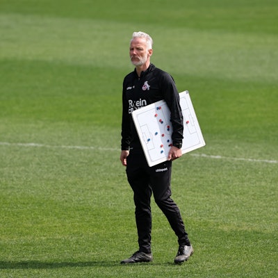 Mark Zimmermann, Trainer der U 21 des 1.FC Köln auf dem Trainingsplatz mit einer Magnettafel in der Hand.