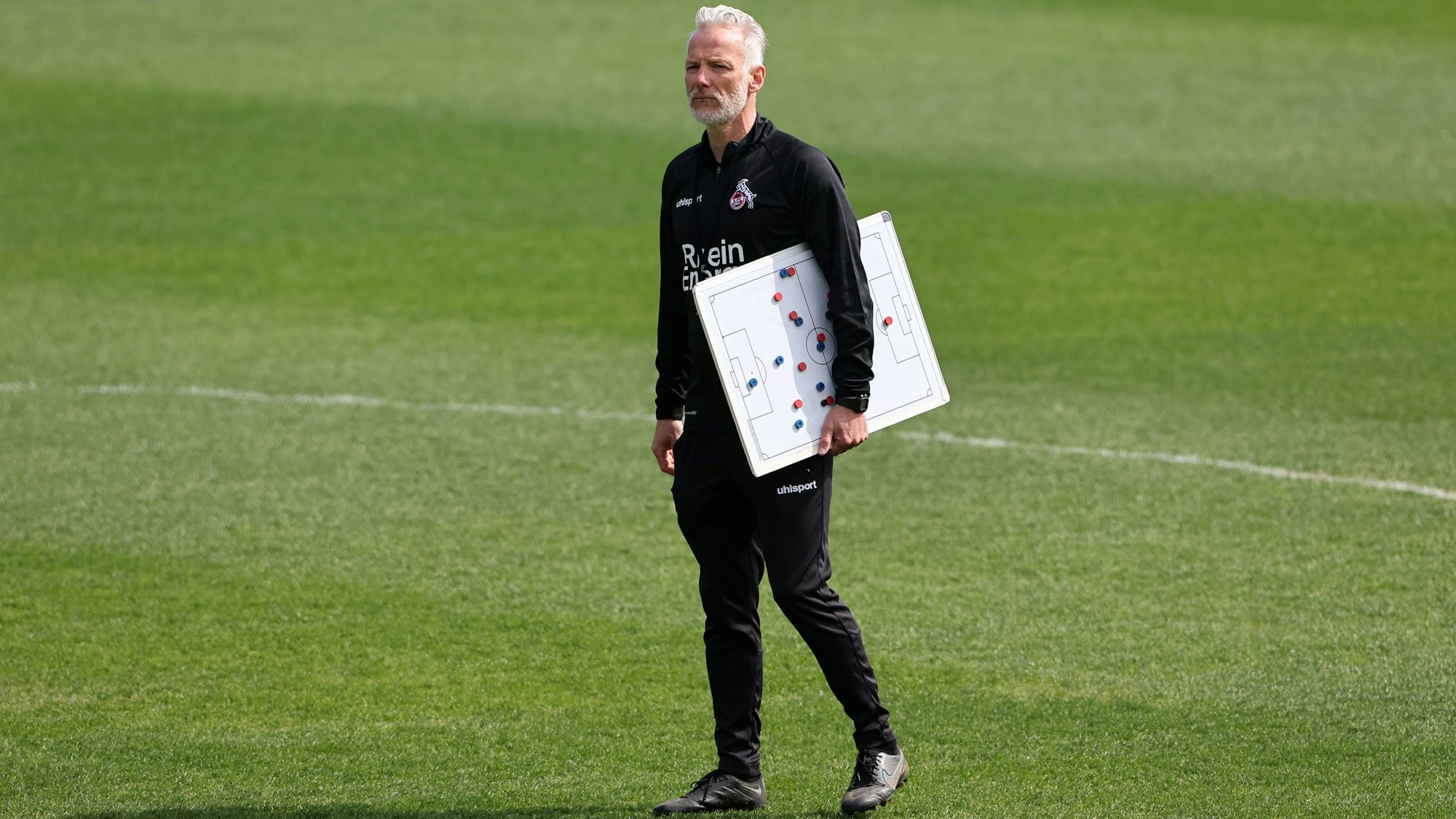 Mark Zimmermann, Trainer der U 21 des 1.FC Köln auf dem Trainingsplatz mit einer Magnettafel in der Hand.