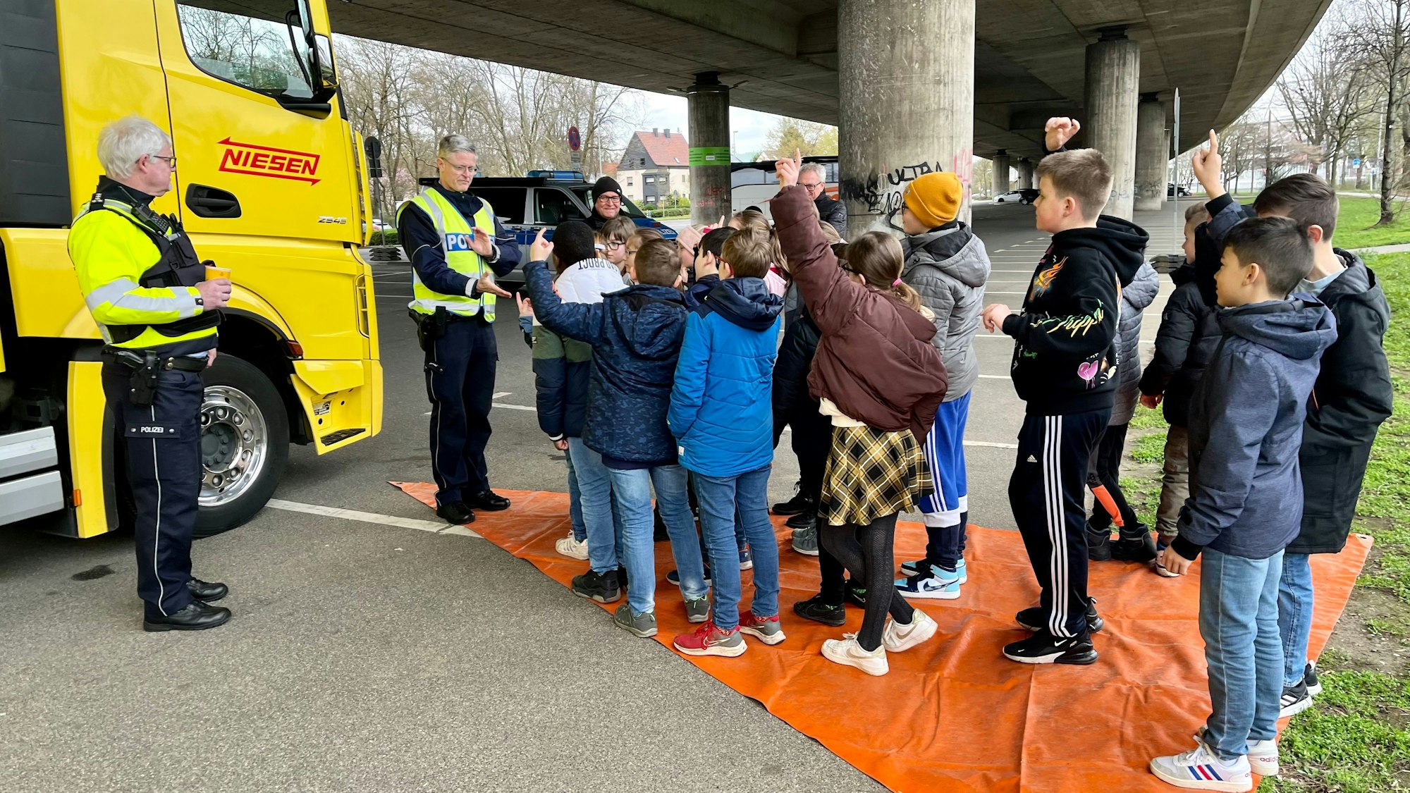 Polizisten zeigen Schülerinnen und Schülern den Toten Winkel eines LKW (Archivbild).