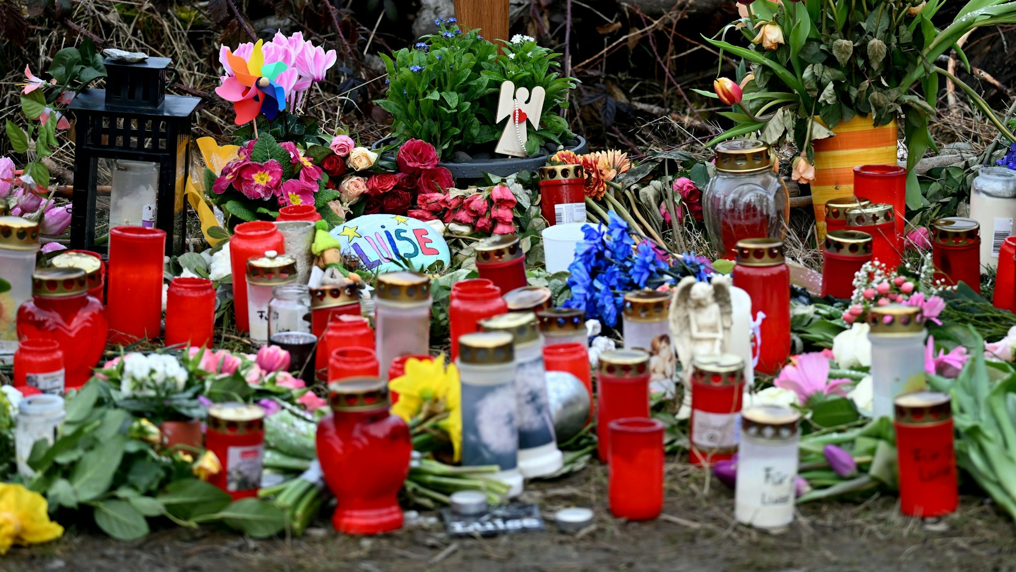 Ein Holzkreuz, zahlreiche Blumen, Kuscheltiere und Kerzen erinnern am Tatort an die getötete 12-jährige Luise.