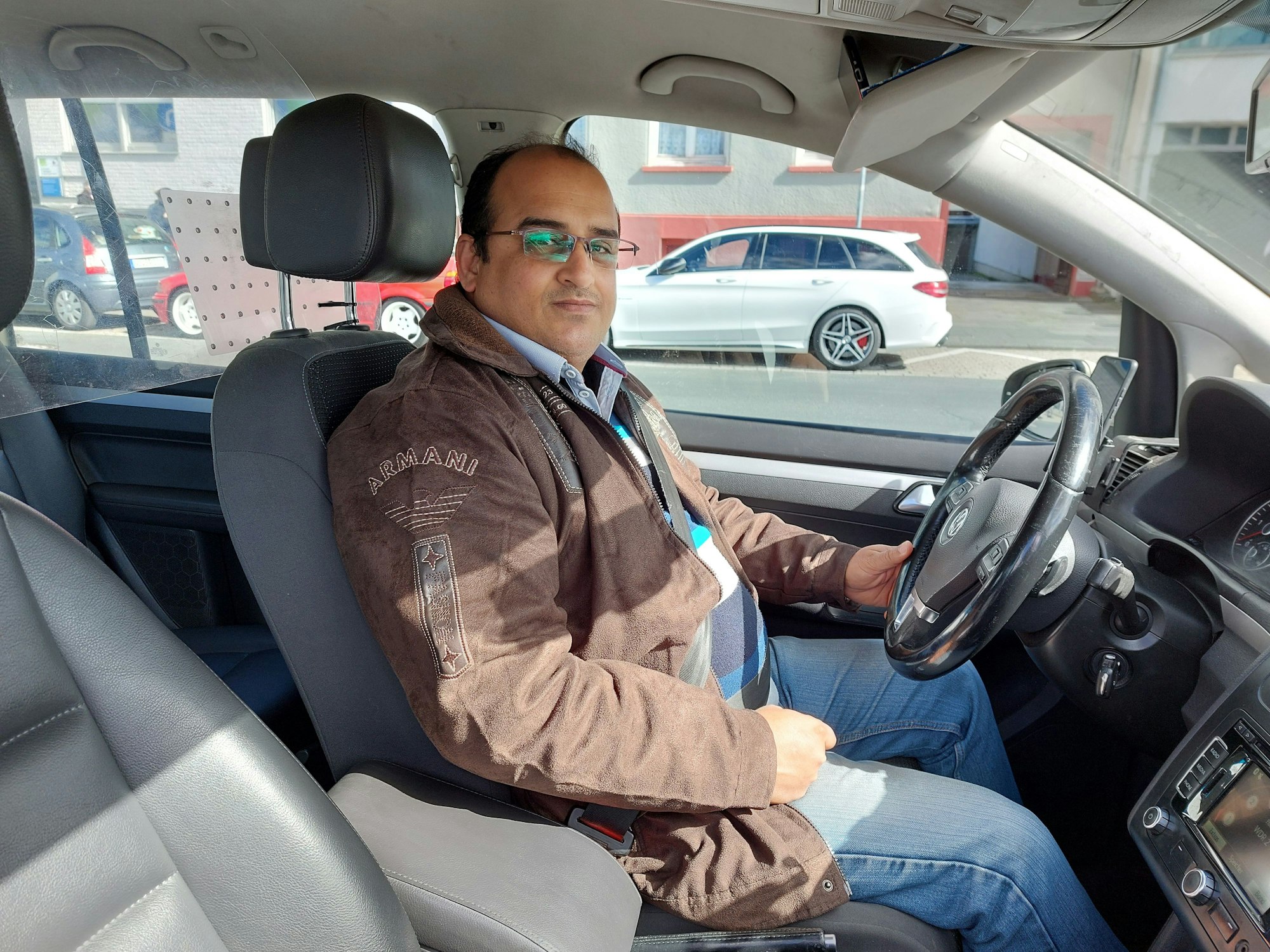 Taxifahrer Muhammad Imran sitzt in einem Taxi.
