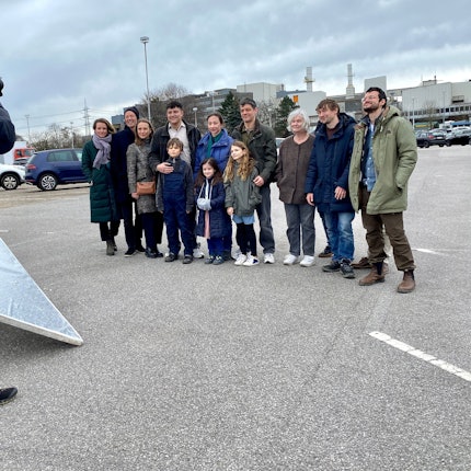 Eine Gruppe Menschen verschiedenen Alters wird von einem Fotografen fotografiert.