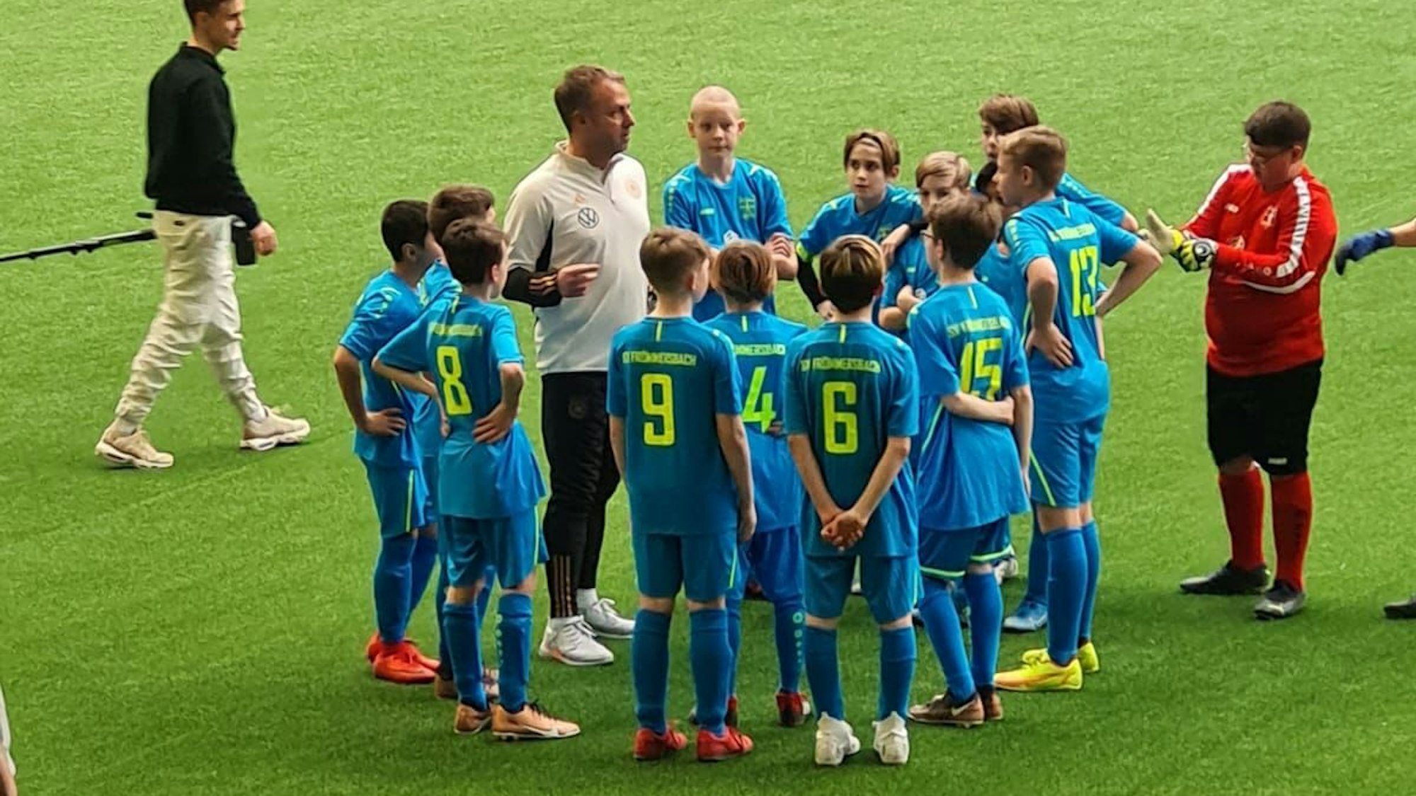 Hansi Flick steht im Kreis mit den Frömmersbacher Spielern.