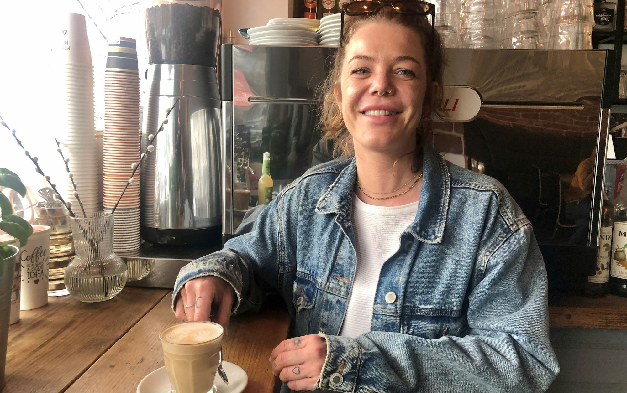 Junge Frau mit Cappuccino im Café