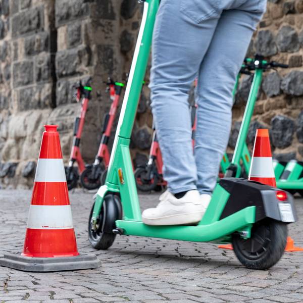 Ein E-Scooter-Fahrer umfährt zwei Pylone auf dem Rudolfplatz in Köln.