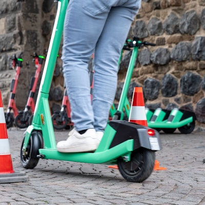 Ein E-Scooter-Fahrer umfährt zwei Pylone auf dem Rudolfplatz in Köln.