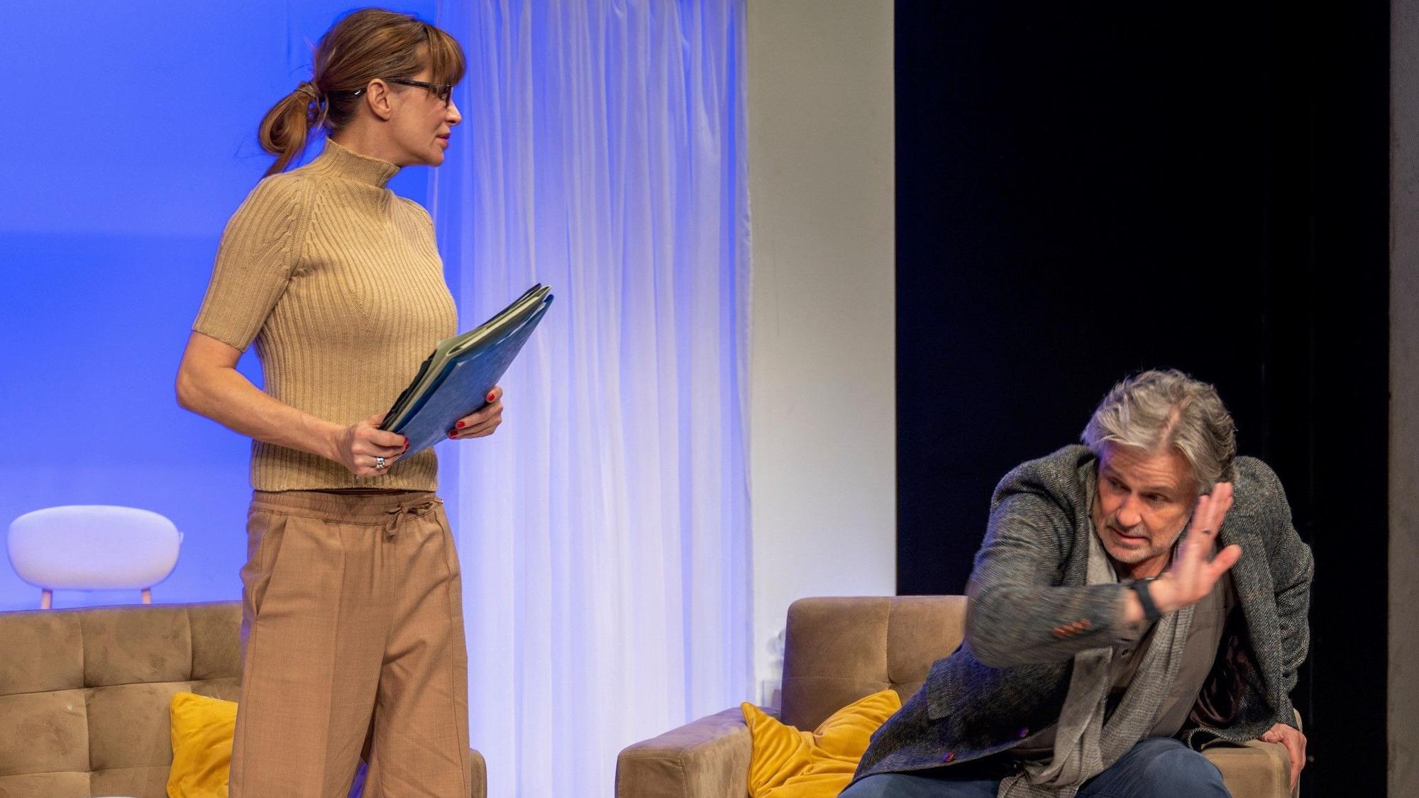 Alexandra Kamp und Timothy Peach auf der Bühne im Theater am Dom. Peach bückt sich vor Kamp, die ihn streng anschaut.