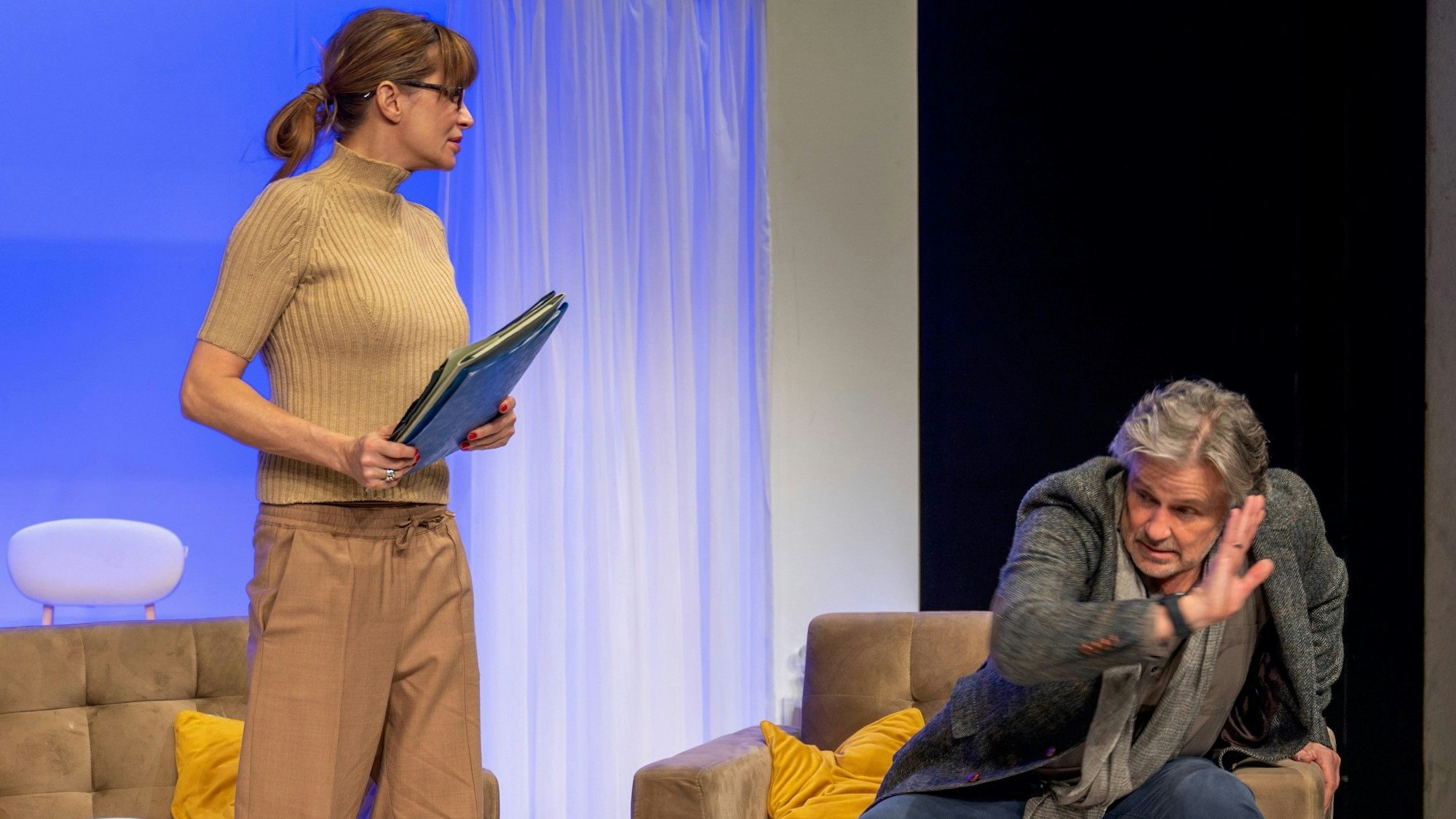 Alexandra Kamp und Timothy Peach auf der Bühne im Theater am Dom. Peach bückt sich vor Kamp, die ihn streng anschaut.