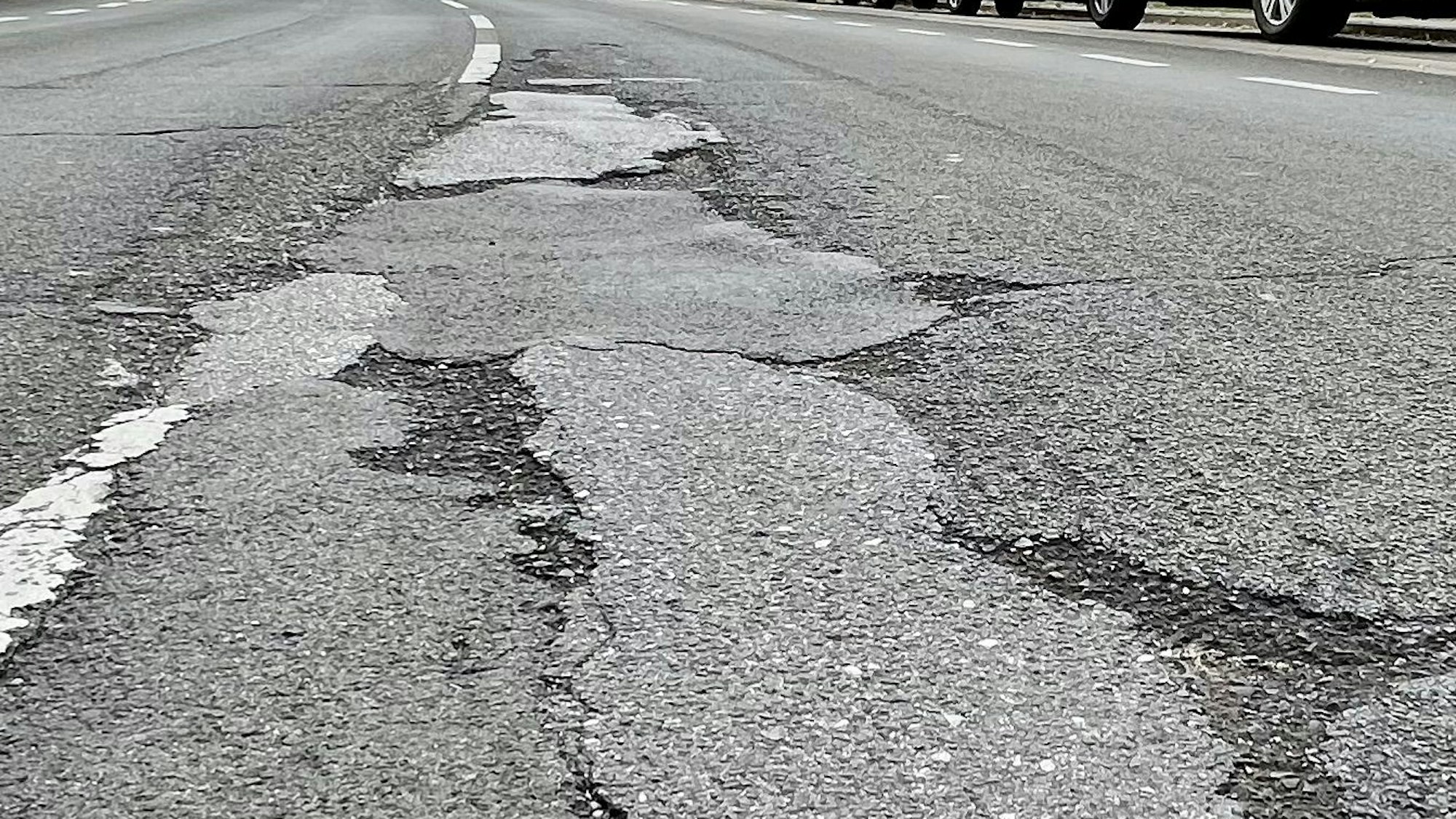 Tiefe Schlaglöcher auf einer Straße.