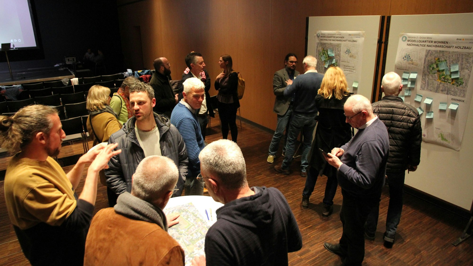 Mehrere Menschen stehen vor Pinnwänden im Rhein-Sieg-Forum und diskutieren.
