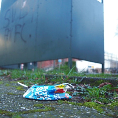 Ein Getränkekarton hinter der Bushaltestelle am Rathaus in Burscheid.