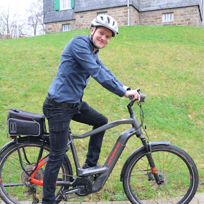 Klimaschutzmanager Rudolf Bergen sitzt auf einem Fahrrad.