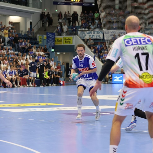 Das Hinspiel des VfL Gummersbach gegen den SC Magdeburg am 08.09.2022. Dominik Mappes läuft auf drei Gegner zu.