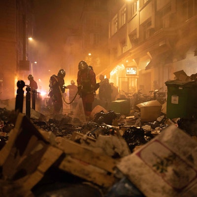 Paris: Feuerwehrleute kontrollieren Müll nach dem Löschen eines Feuers während einer Demonstration. In Frankreich haben sich die Streiks und Proteste gegen die Rentenreform zugespitzt.