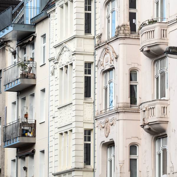 In Pastelltönen gestrichene Wohngebäude stehen an einer Straße in Köln.