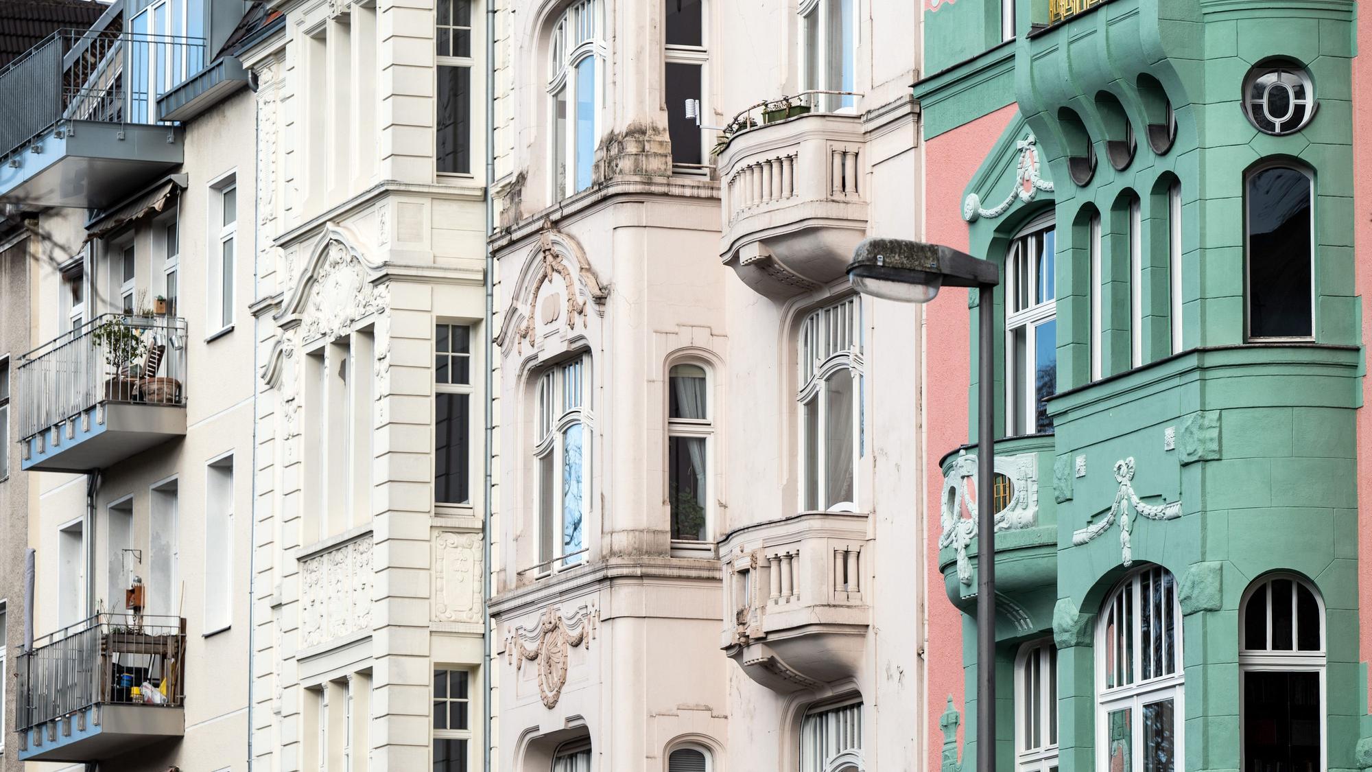 In Pastelltönen gestrichene Wohngebäude stehen an einer Straße in Köln.