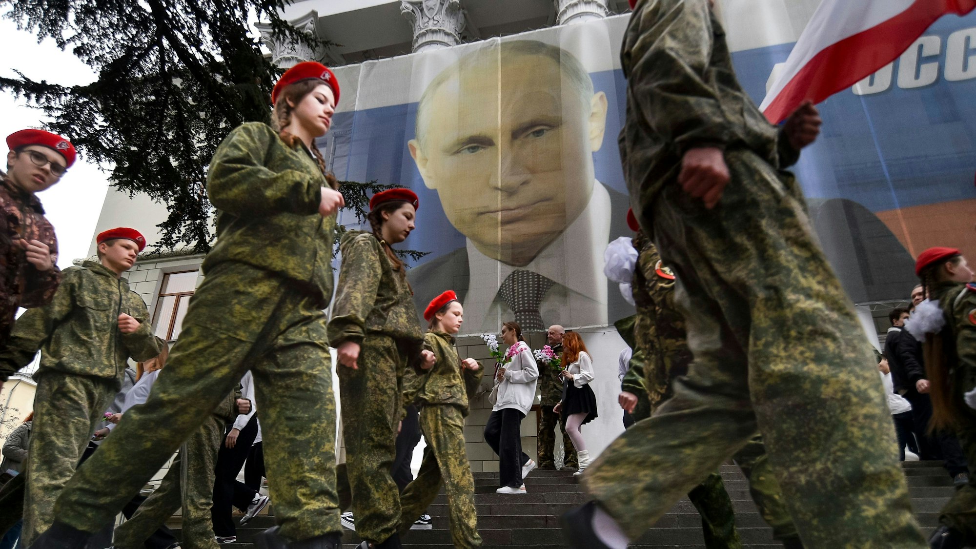 Uniformierte Jugendliche marschieren in Jalte anlässlich einer Aktion zum neunten Jahrestag der Krim-Annexion an einem Bildnis des russischen Präsidenten Wladimir Putin vorbei.(Archivbild)