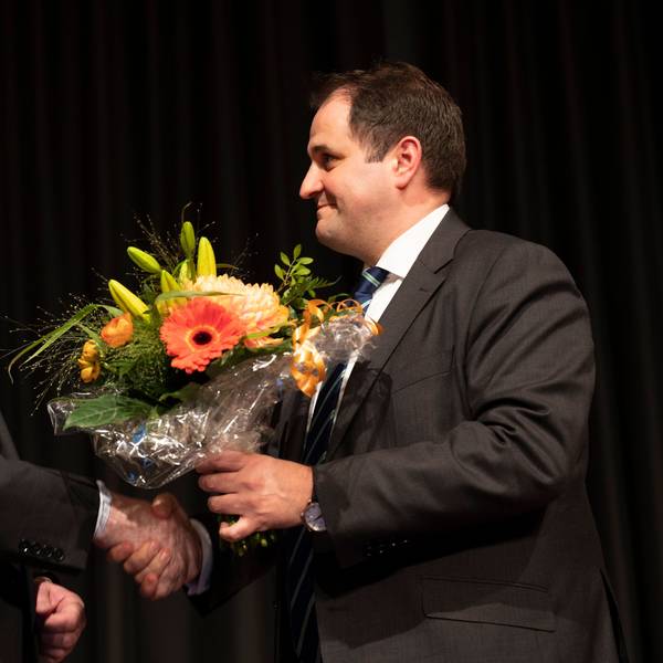 Das Bild zeigt zwei Männer, die sich die Hand geben.