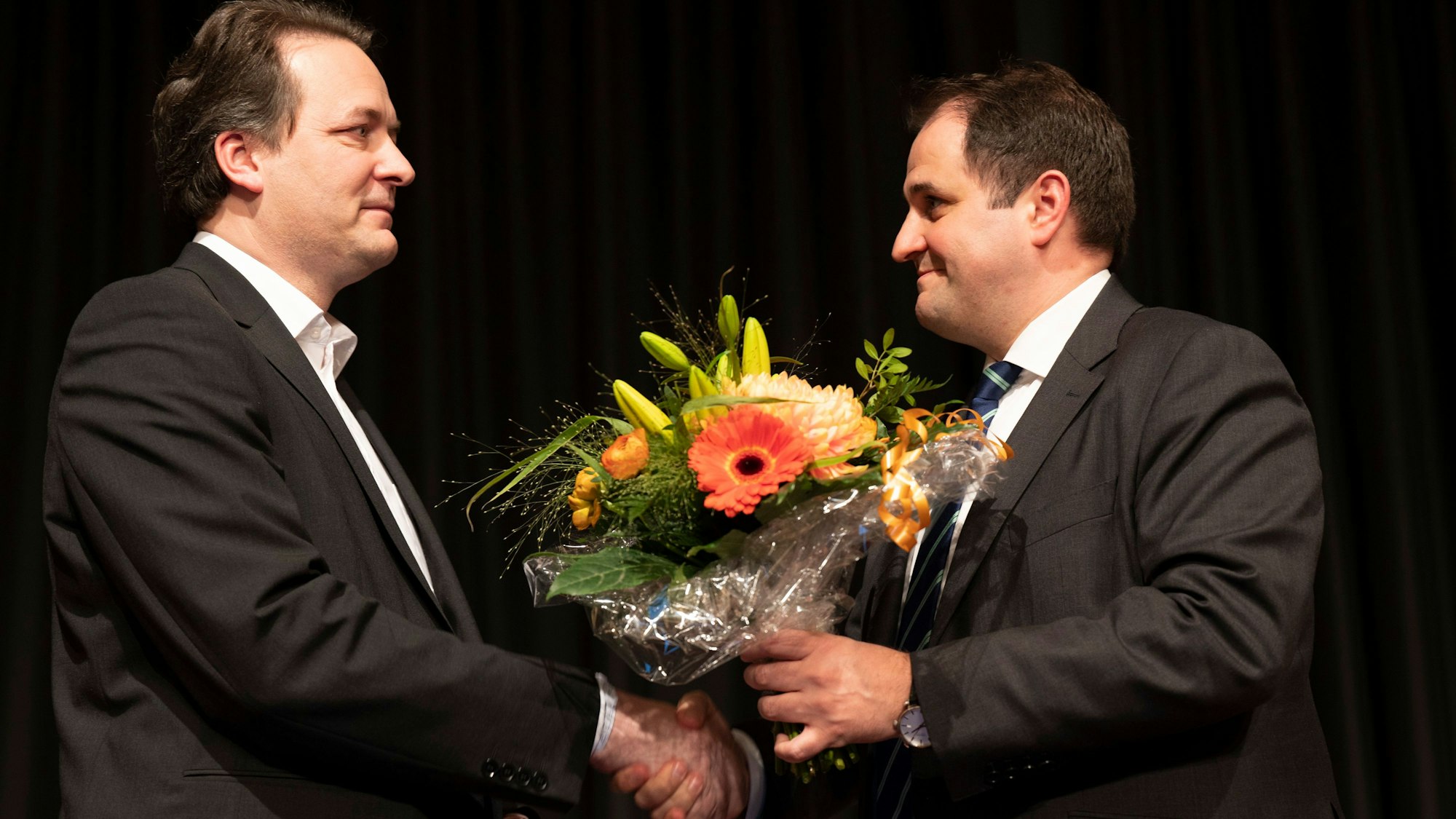 Das Bild zeigt zwei Männer, die sich die Hand geben.