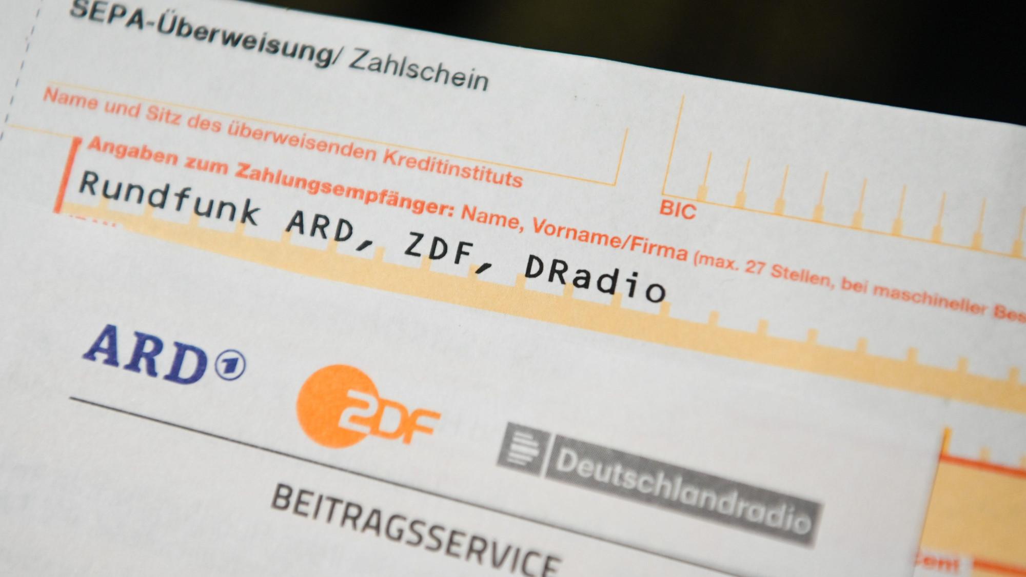 Auf einem Tisch liegt ein Anschreiben und Überweisungsträger für die Rundfunkgebühren.