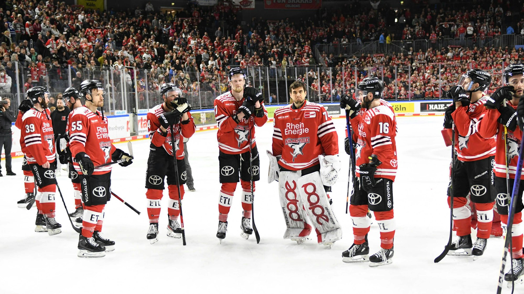 Enttäuschte Haie-Spieler auf der Eisfläche in der Lanxess Arena.