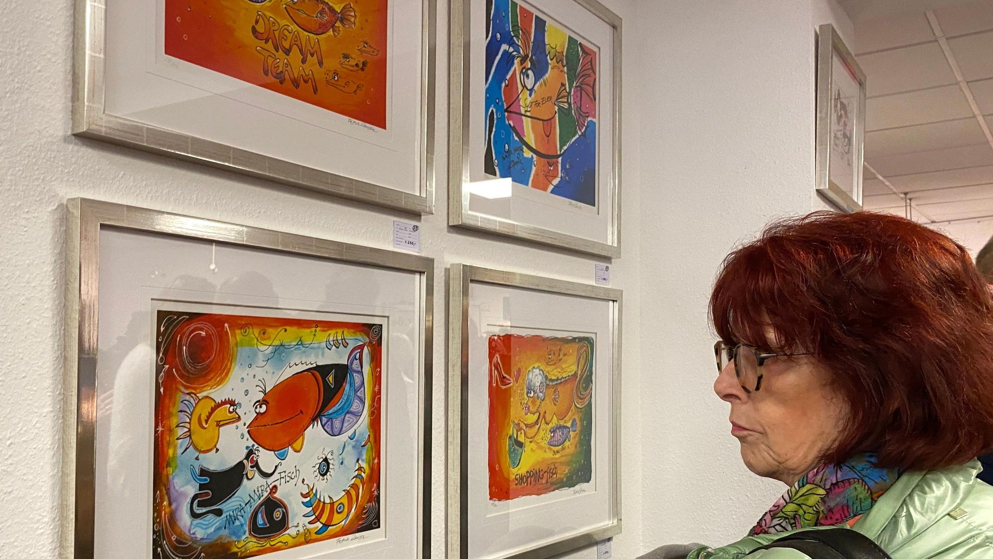 Das Bild zeigte eine Frau, die sich mehrere Bilder von Frank Zander anschaut.
