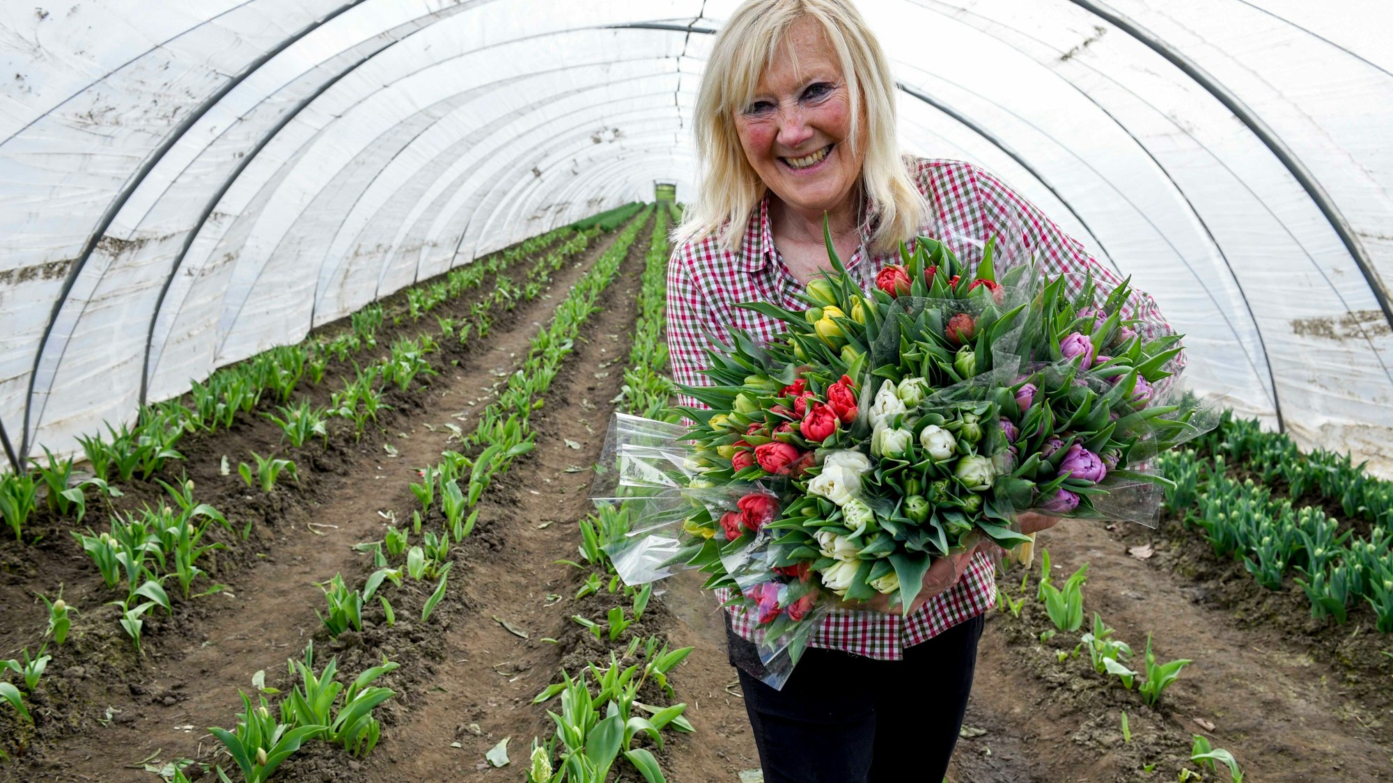Das Bild zeigt Gertrud Zens mit einem Strauß Tuplen in den Händen.