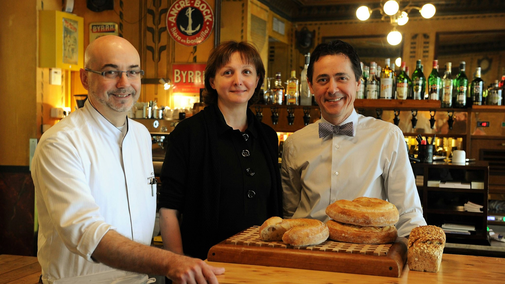 Das Trio steht hinter dem Tresen.