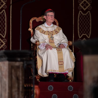 Kardinal Rainer Woelki sitzt während eines Gottesdienstes im Dom zu Fulda während der Herbstvollversammlung der Deutschen Bischofskonferenz 2022 auf einem barocken Stuhl.