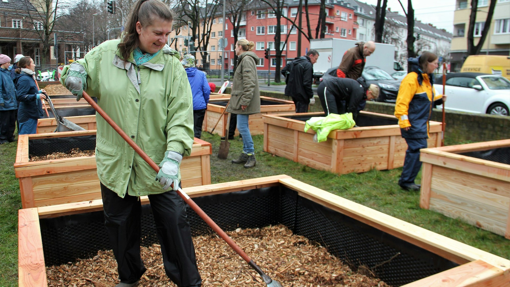 Die Gärtnerin arbeitet mit einem Rechen in ihrem Beet.