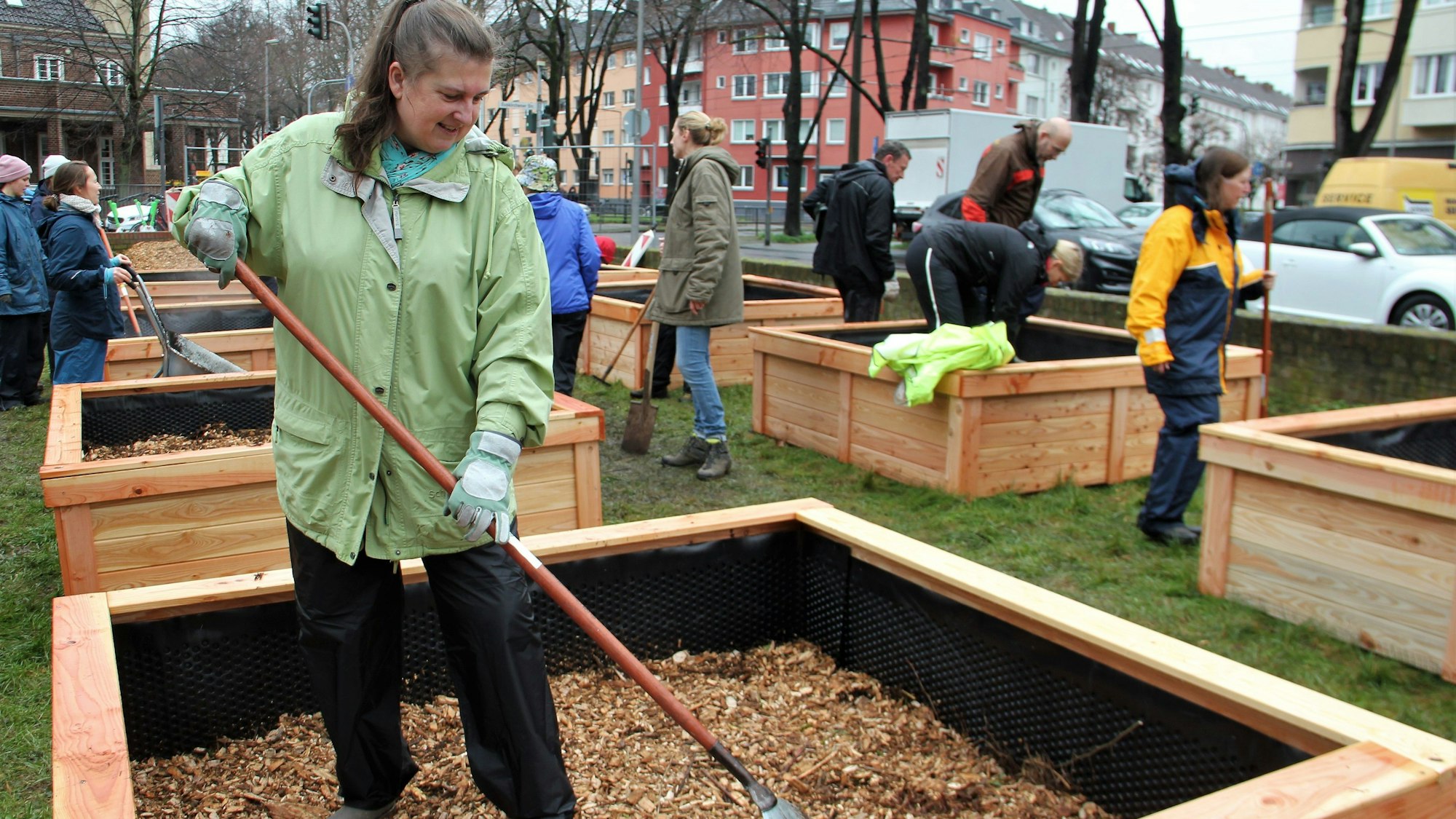 Die Gärtnerin arbeitet mit einem Rechen in ihrem Beet.