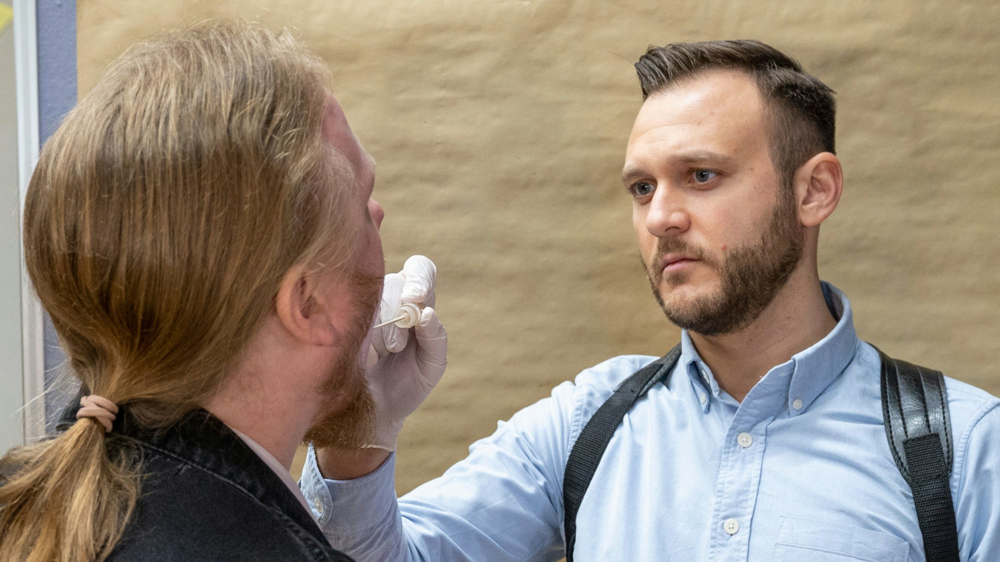 Eine Speichelprobe wird mit Wattestäbchen entnommen.